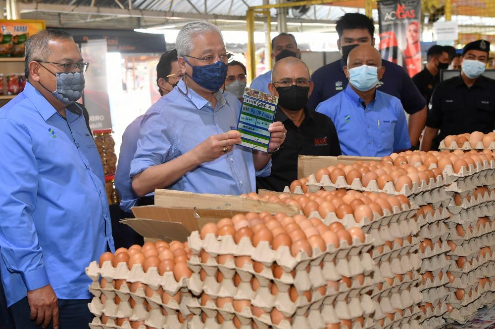 Perdana Menteri Datuk Seri Ismail Sabri Yaakob (dua, kiri) menunjukkan harga telur semasa melakukan tinjaun harga barang di MyFarm Outlet Kasih Putrajaya hari ini. Turut sama Menteri Pertanian dan Industri Makanan, Datuk Seri Dr Ronald Kiandee (tiga, kiri). BERNAMApix