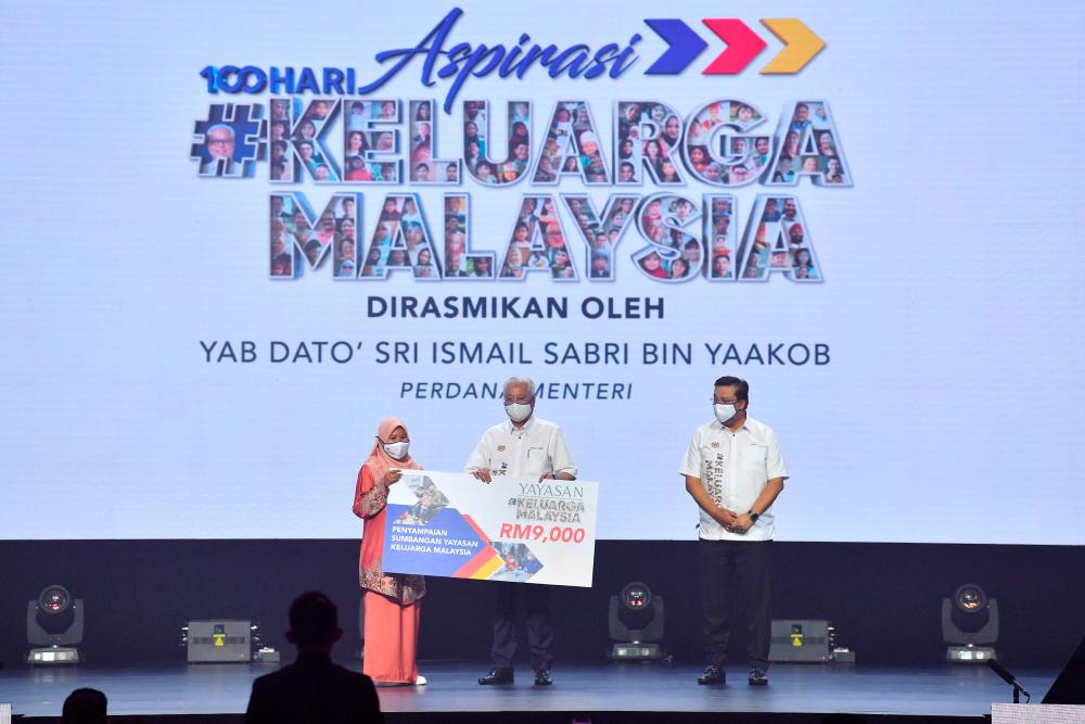 Prime Minister Datuk Seri Ismail Sabri Yaakob (center) presented a contribution from the Malaysian Family Foundation for Families affected by Covid-19 during launching 100 Days Aspirations #KeluargaMalaysia held at the Kuala Lumpur Convention Center today. Also present, Chief Secretary to the Government Tan Sri Mohd Zuki Ali (right). BERNAMApix