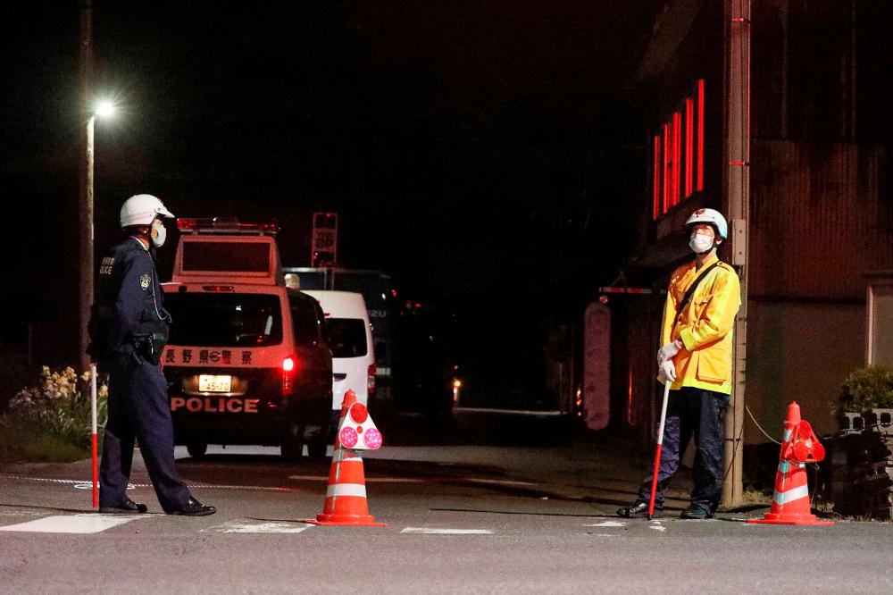 Police officers stand guard near the scene of a standoff where a suspect, believed to be a farmer in his 30s, was holed up inside a building in the Ebe area of Nakano, Nagano Prefecture, late on May 25, 2023. A woman and two male police officers were killed in a shooting and stabbing attack at a farm in central Japan on May 25, media reported/AFPPix