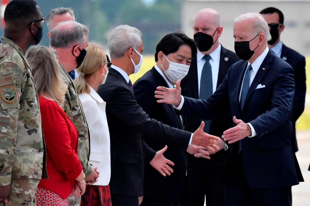 Japan’s Foreign Minister Yoshimasa Hayashi (C) and US Ambassador to Japan Rahm Emanuel (C-L) greet US President Joe Biden (2nd R) after arriving at Yokota Air Base in Fussa, Tokyo prefecture on May 22, 2022. AFPPIX