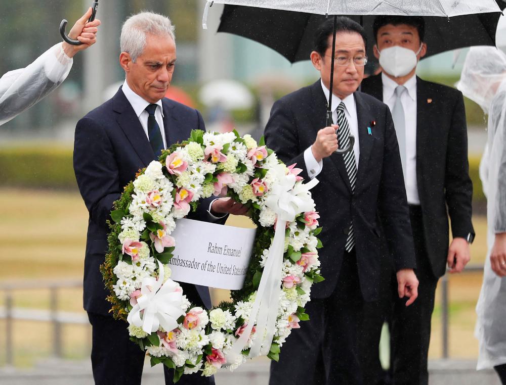 US Ambassador to Japan Rahm Emanuel (L), accompanied by Japanese Prime Minister Fumio Kishida, lays a wreath at the Cenotaph for atomic bomb victims at the Peace Memorial Park in Hiroshima on March 26, 2022. AFPPIX