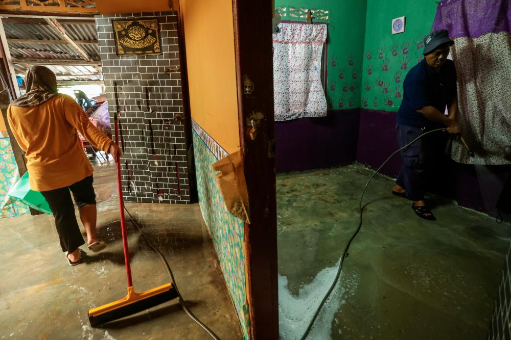 Penduduk Kampung Tenang mencuci kediaman mereka selepas dinaiki air susulan banjir yang melanda beberapa tempat sekitar negeri Johor ketika tinjauan hari ini/fotoBERNAMA