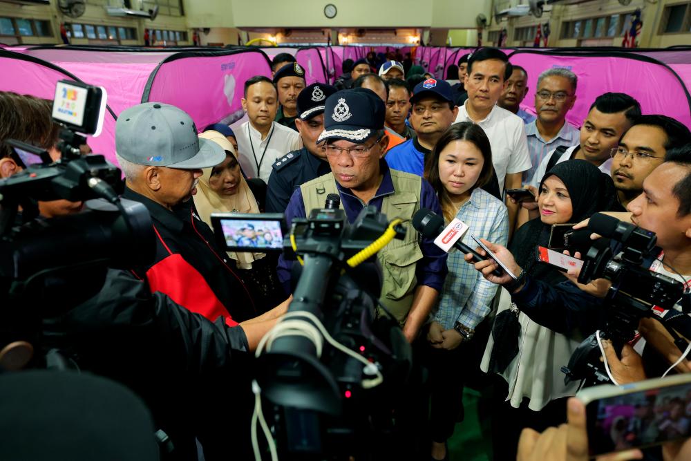 KLUANG, March 3 -- Home Minister Datuk Seri Saifuddin Nasution Ismail (centre) when met by media practitioners during a visit to the Temporary Transfer Center (PPS) of the Kampung Melayu People’s Hall today. BERNAMAPIX