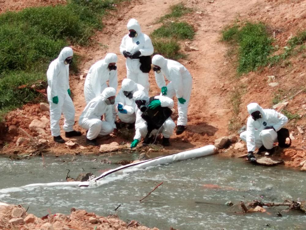 HAZMAT team members conduct an inspection before the cleaning of toxic waste at Sungai Kim Kim, Pasir Gudang on March 14, 2019. — BBX