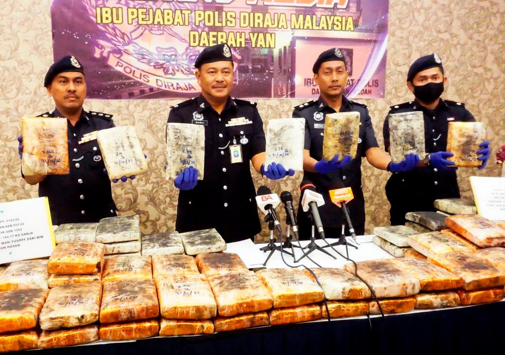YAN, Jan 2 -- Yan District Police Chief DSP Shahnaz Akhtar Haji (second, left) shows a compressed lump of suspected marijuana that was seized in the water line area of Kampung Makau today. BERNAMAPIX