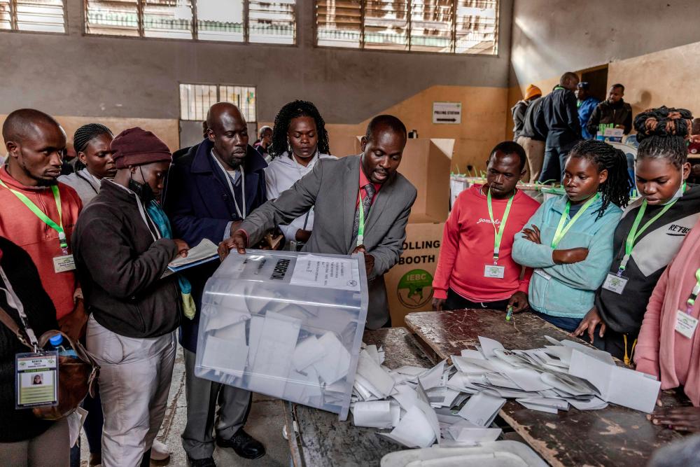 An Electoral Commission Official proceeds to count votes after the official closing of the polls during Kenya's general election at Mathare Social Hall in Nairobi, Kenya, on August 9, 2022. - AFPPIX