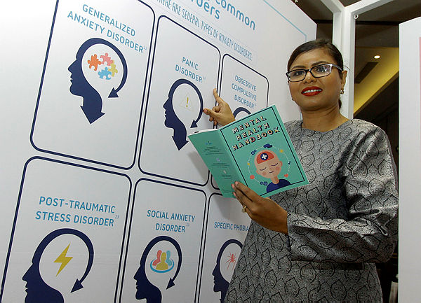 Country Medical Lead Pfizer Malaysia Dr Jerusha Naidoo taking a picture with the Mental Health Handbook today — Bernama