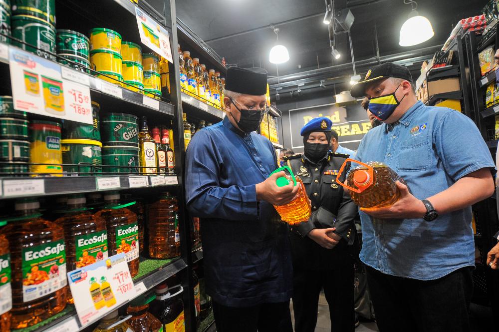 KUALA LUMPUR, July 1 - Communications and Multimedia Minister Tan Sri Annuar Musa together with Federal Territory Ministry of Domestic Trade and Consumer Affairs Director Ariffin Samsudin saw the price tag on bottled cooking oil while surveying the price of subsidized goods at a supermarket today. --BERNAMAPIX