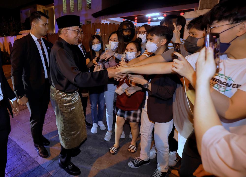 Perdana Menteri Datuk Seri Anwar Ibrahim (dua, kiri) beramah mesra dengan para penduduk setempat yang hadir sejurus pulang ke kediamannya di Sungai Long, kira-kira 9.55 malam selepas sidang media di Sungai Long Clubhouse hari ini./fotoBERNAMA