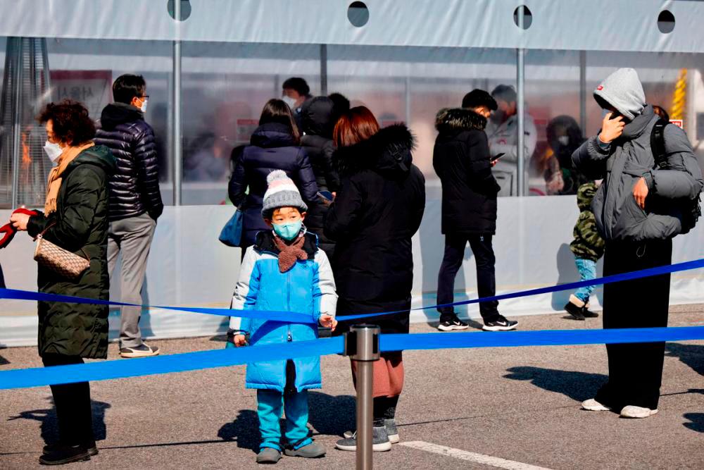 People wait in line to undergo the coronavirus disease (Covid-19) test at a temporary testing site set up in Seoul, South Korea, February 16, 2022. REUTERSpix