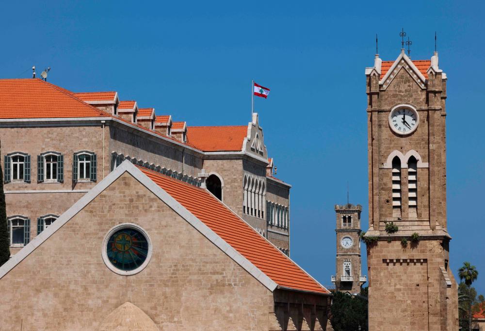 A Church’s clock tower (front) next to the governmental palace in Beirut indicates the new summer time on March 27, 2023. AFPPIX