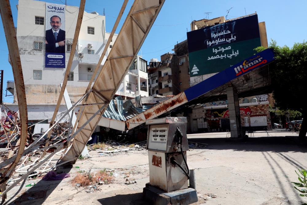 Electoral campaign posters are pictured near a gas station damaged in the August 2020 port blast, ahead of the parliamentary election, in Mar Mikhael neighborhood, in Beirut, Lebanon May 13, 2022. REUTERSpix