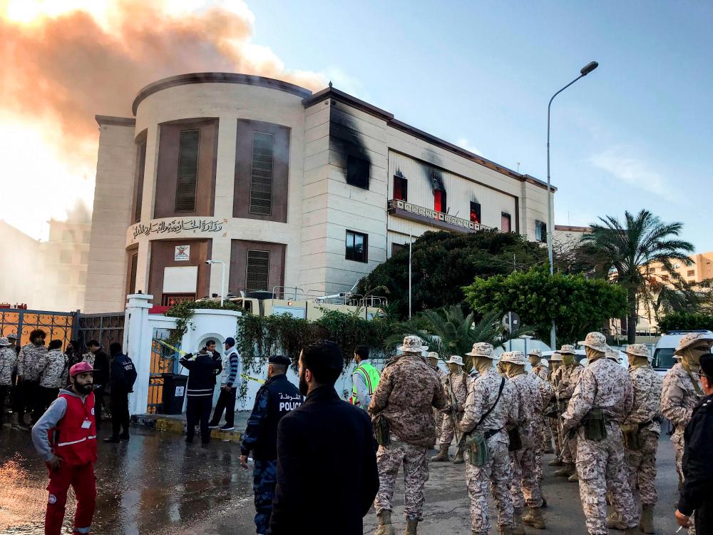 A picture taken on Dec 25, 2018 shows paramedics and security officers at the scene of an attack outside the Libyan foreign ministry headquarters in the capital Tripoli. — AFP