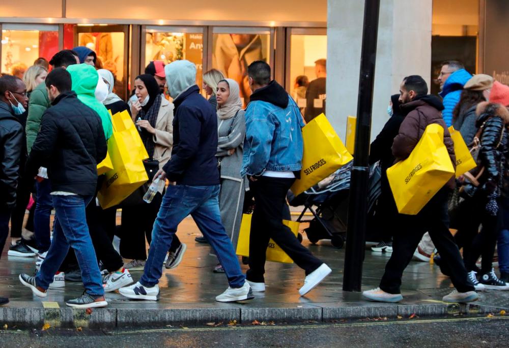 Pedestrians walk with shopping bags on “Black Friday” in the West End shopping district of London, Britain, November 26, 2021. REUTERSpix