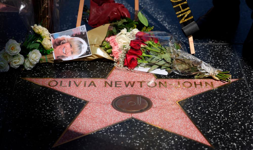 $!Fans laid flowers upon Olivia Newton-John’s star on the Hollywood Walk of Fame. – Reuters