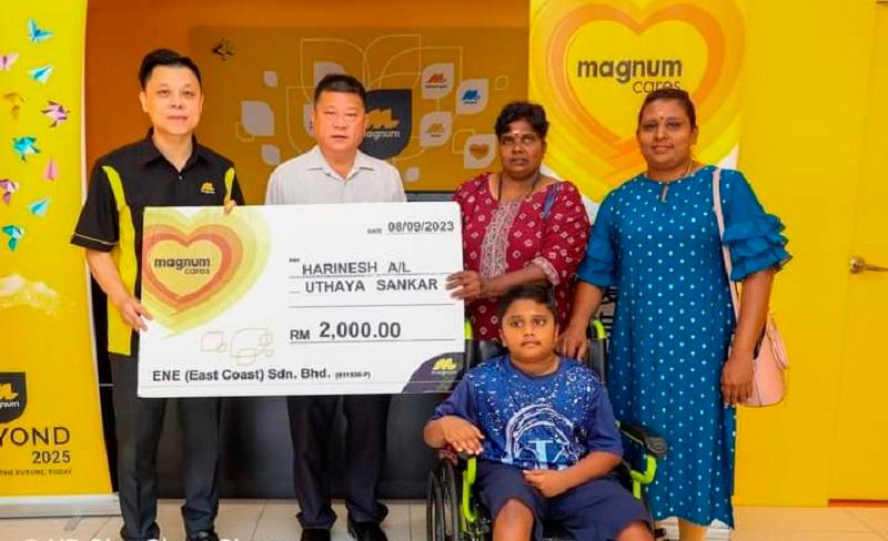 MagnumCares ‘Cepat-Cepat Tolong’ programme, through Magnum East Coast &amp; Selangor vice-president (regional head) Lim See Chin (left), presenting the cash donation to U. Harinesh (on wheelchair), witnessed by Pahang Exco member Sim Chon Siang (2nd from left).