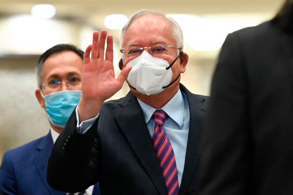Malaysia's former prime minister Najib Razak (C) waves as he arrives at the federal court in Putrajaya on August 19, 2022. AFPPIX