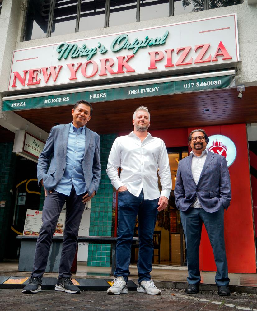 Helfman (middle), Subra (left) and Subahan Kamal outside Mikey’s Original New York Pizzaoutlet in New York.