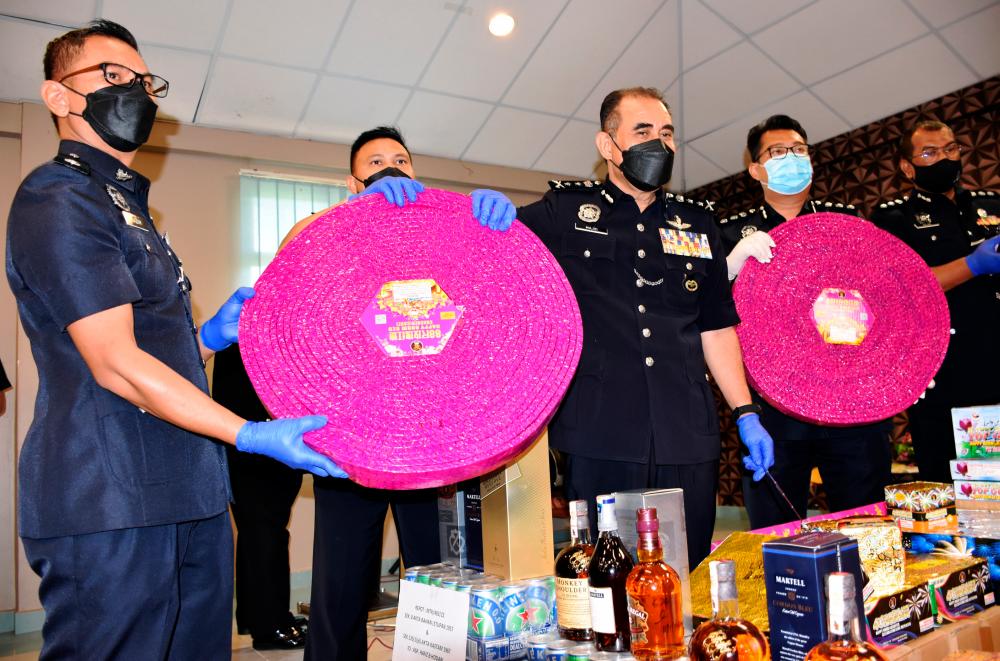 MELAKA, 17 Jan -- Ketua Polis Melaka, Datuk Abdul Majid Mohd Ali (tengah) menunjukkan pelbagai jenis mercun dipercayai tanpa permit dan minuman keras tidak bercukai yang dirampas pada sidang media di Ibu Pejabat Polis Kontinjen Melaka hari ini. fotoBERNAMA