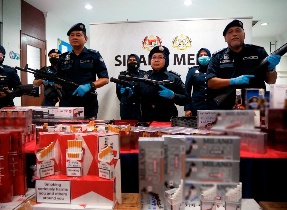 MELAKA, 2 August -- Director of the Royal Malaysian Customs Department (JKDM) Melaka Norlela Ismail (centre) shows among the fake firearms and some confiscated cigarettes and smuggled liquor at a press conference in Ayer Keroh today. BERNAMAPIX