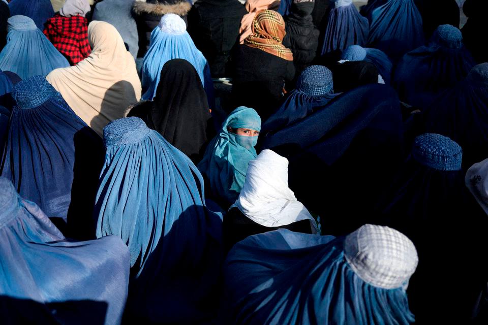A girl sits in front of a bakery in the crowd with Afghan women waiting to receive bread in Kabul, Afghanistan, January 31, 2022. REUTERSPIX