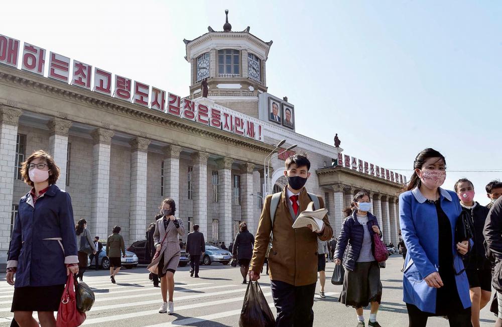 File photo: People wearing protective face masks walk amid concerns over the new coronavirus disease (Covid-19) in front of Pyongyang Station in Pyongyang, North Korea April 27, 2020, in this photo released by Kyodo. Kyodo/via REUTERSpix