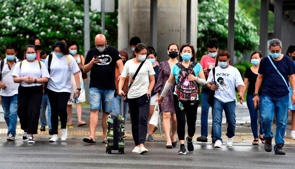 People wearing face masks cross a road amid the coronavirus disease (Covid-19) outbreak in Singapore May 14, 2021. REUTERSpix