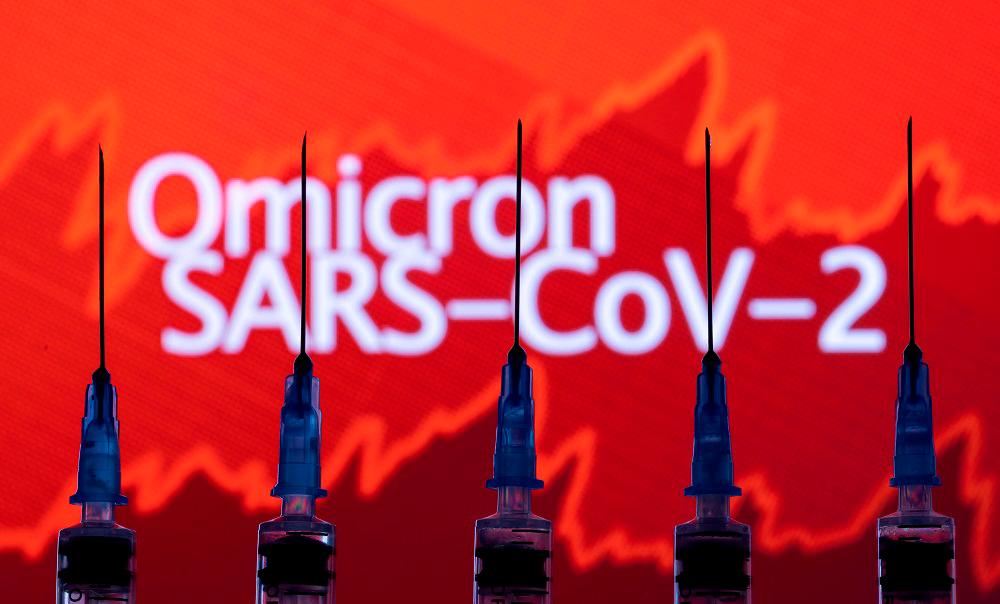 FILE PHOTO: Syringes with needles are seen in front of a displayed stock graph and words Omicron SARS-CoV-2 in this illustration taken, November 27, 2021. REUTERSpix