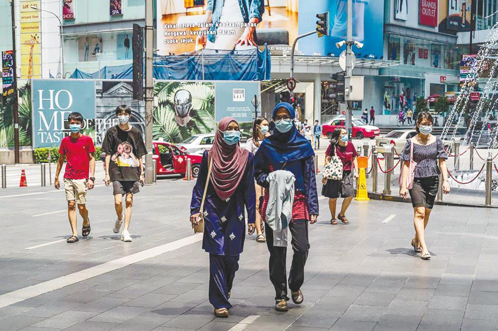 People walking outside a shopping mall in Kuala Lumpur. It is hoped that the budget’s expansionary approach will boost overall consumer and business spending which in turn will translate into a second round effect that will benefit the rest of the economy. – AFPPIX