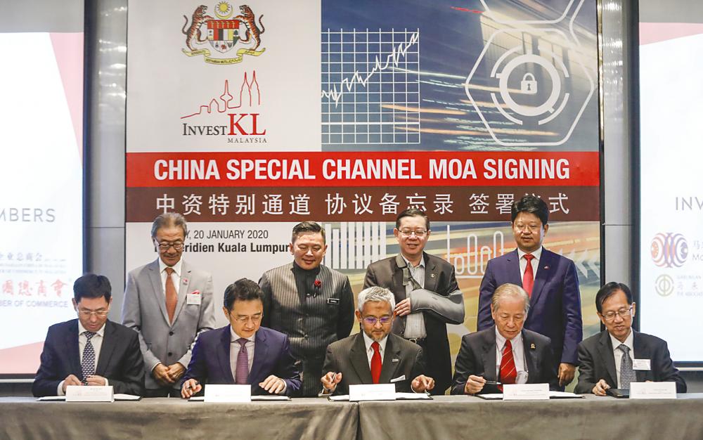 (Seated from left) China Enterprises Chamber of Commerce in Malaysia president Zhang Min, The Associated Chinese Chambers of Commerce and Industry of Malaysia president Tan Sri Ter Leong Yap, Muhammad Azmi, Malaysia-China Business Council CEO Teng Kok Liang and Malaysia-China Chamber of Commerce president Datuk Tan Yew Sing signing the MoAs. Looking on are (from left) InvestKL chairman Datuk Seri Michael Yam, International Trade and Industry Minister Datuk Darell Leiking, Lim, and China’s ambassador to Malaysia Bai Tian. – Ashraf Shamsul/THE SUN