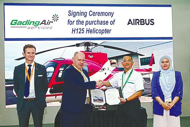 Airbus vice-president/head of marketing and sales, Asia-Pacific, Fabrice Rochereau and Shamsul Kamar exchanging documents witnessed by (far left) de Pascal and Gading group executive director Siti Amirah Nur Shafiqah Johari.