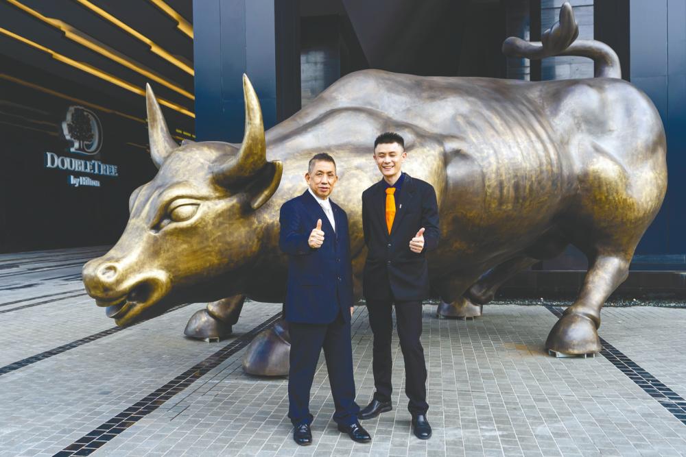 Kim Hong (left) and I-Bhd executive director Lim Boon Soon with the Charging Bull, a landmark at the Finance Avenue in i-City precinct. The Charging Bull at Finance Avenue in i-City symbolises resilience of the Malaysian economy and the emergence of i-City as a financial hub of the future in Selangor.