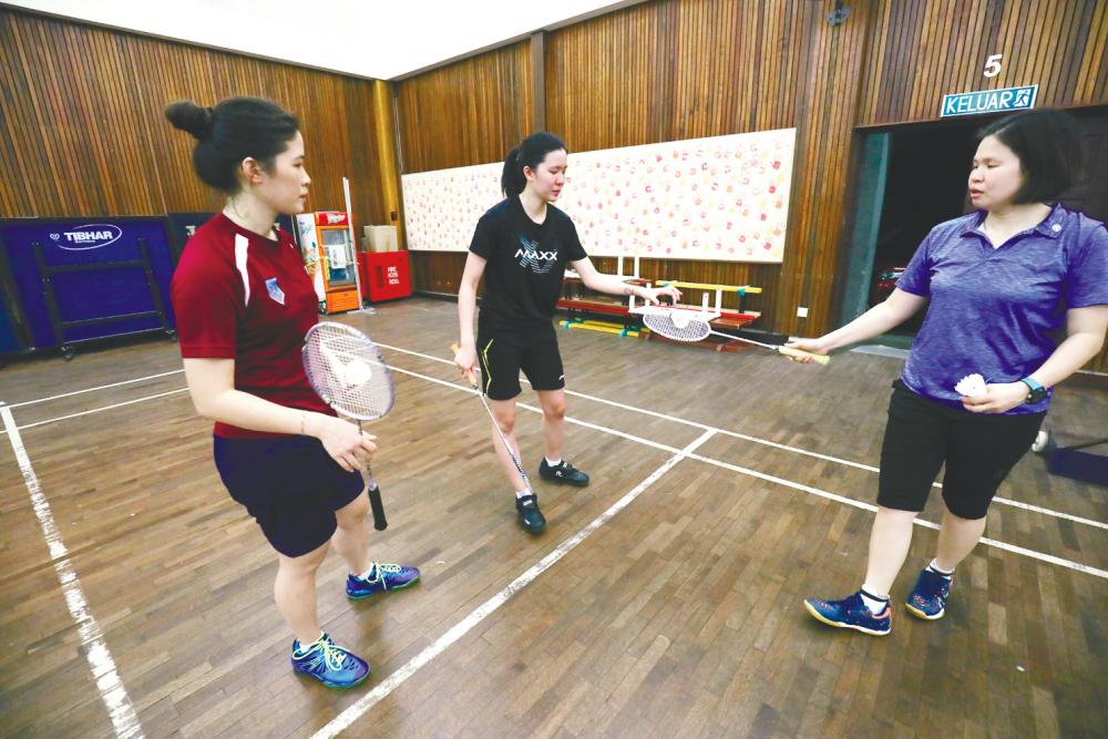 From left: Boon and Tung with their coach Sabrina Chong during training at the badminton court in Sekolah Jenis Kebangsaan Cina Puay Chai in Petaling Jaya. – HAFIZ SOHAIMI/THESUN