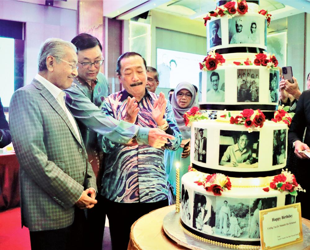 Tan with his son, Berjaya Deputy Chairman Datuk Seri Robin, and Mahathir admiring the unique birthday cake during the event yesterday. – PIC COURTESY OF BERJAYA
