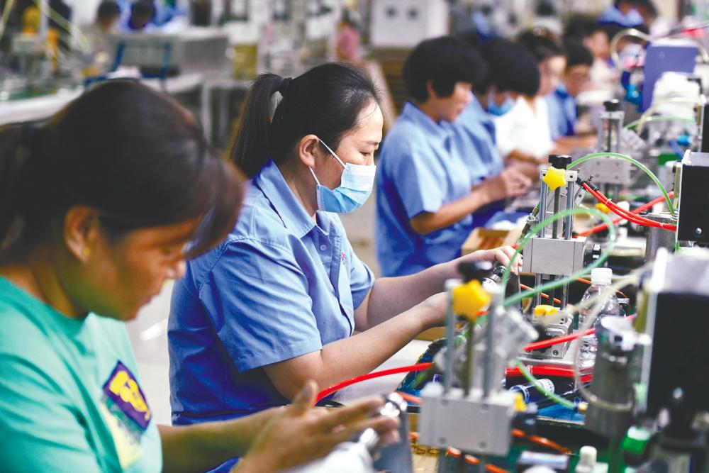 Workers on an assembly line at a factory in Fuyang city, China. There is ongoing friction between the US and China that affects a key sector in Malaysia-China trade – electronics. – AFPpix