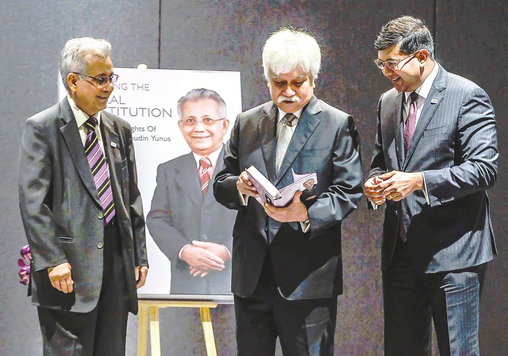 Tuanku Muhriz flanked by Hishamudin (left) and Saravana at the book launch in Kuala Lumpur on Wednesday. – ADIB RAWI YAHYA/THESUN