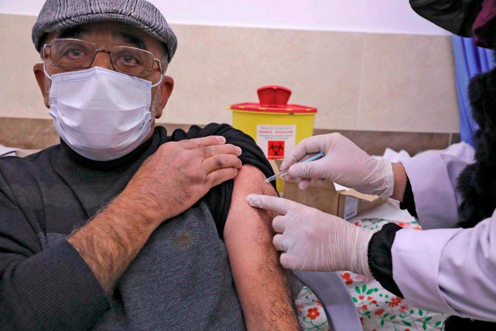 Palestinian Red Crescent health workers get vaccinated against Covid-19 in the West Bank city of Hebron, on February 11, 2021. AFP / HAZEM BADER