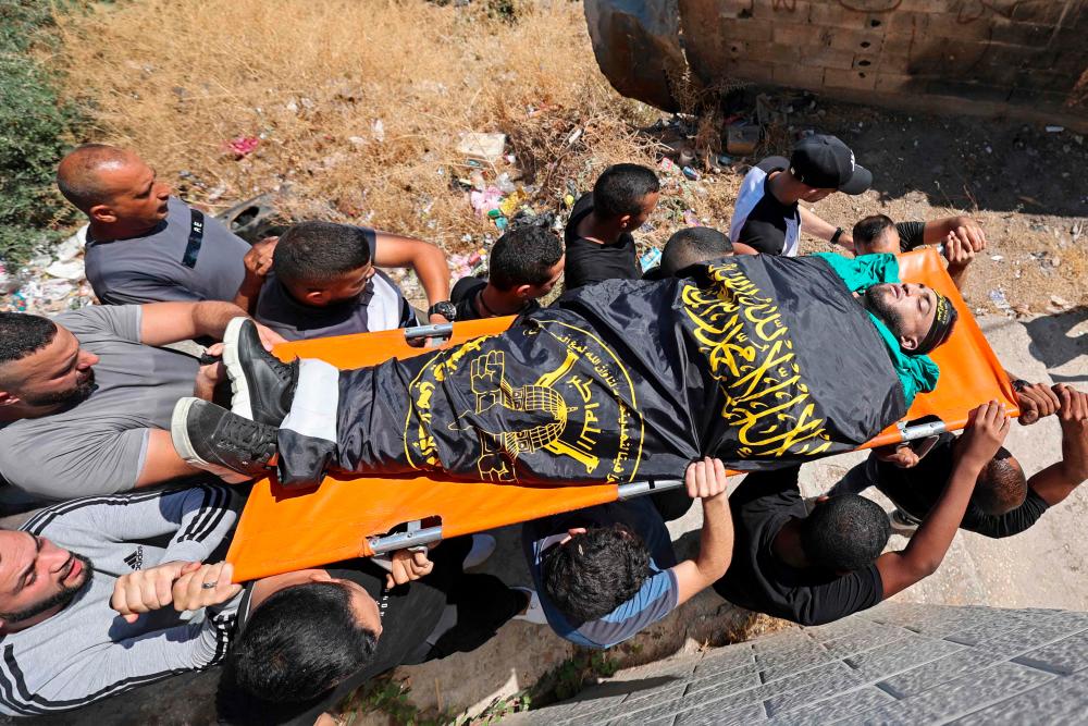 Mourners carry the body of Palestinian Mohammad Marei, who was killed amid an Israeli raid, during his funeral in the hotspot town of Jenin in the occupied West Bank/AFPPix