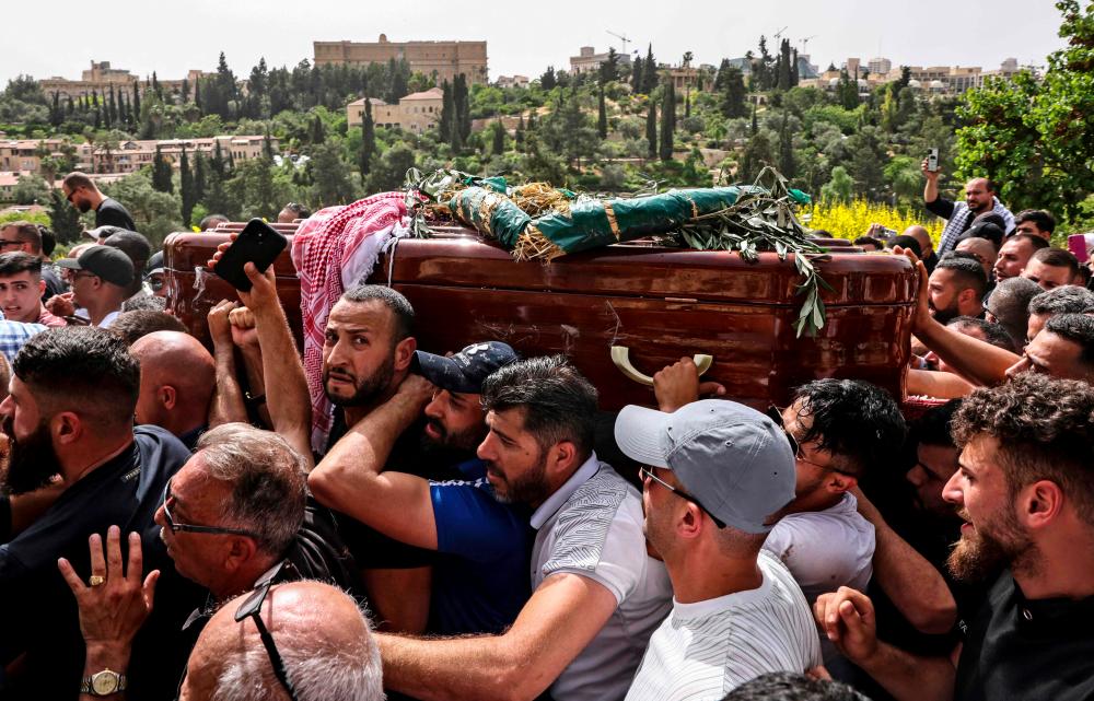 Palestinian mourners carry the coffin of slain Al-Jazeera journalist Shireen Abu Akleh towards the Mount Zion cemetery following a church service in Jerusalem/AFPPix