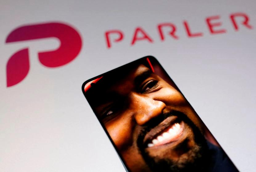 American rapper Kanye West’s picture is seen on a smartphone in front of the logo of social media app Parler in this Illustration taken, October 17, 2022. REUTERSPIX