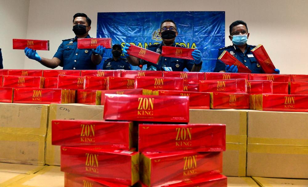 BUTTERWORTH, August 10 — Penang Customs Director, Datuk Abdul Halim Ramli (centre) with his officers showing cartons of smuggled cigarettes seized during a press conference at the Customs Enforcement Store, in Bagan Jermal today. BERNAMAPIX