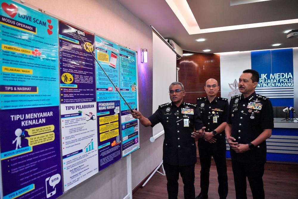 KUANTAN, August 8 — Pahang Police Chief Datuk Seri Ramli Mohamed Yoosuf (left) shows posters to raise public awareness about commercial crimes such as “love scam”, ah long and so on at a special press conference of the Pahang Commercial Crime Investigation Department. at the Pahang Contingent Police Headquarters here today. BERNAMAPIX