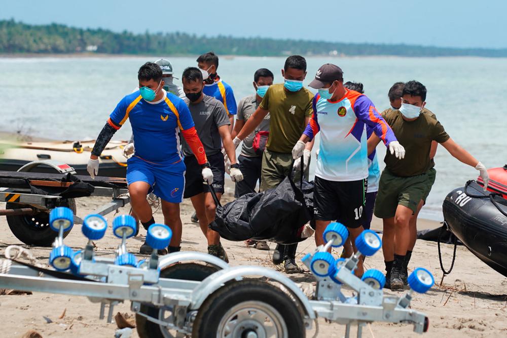 Rescue workers carry a body bag containing a resident's dead body, victim of a landlside that slammed Pilar village in Abuyog town, Leyte province/AFPPix