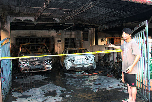 Lian Wai Hung, 24 showing the fire damage done to vehicles owned by his family in Taman Tupai Mas, Taiping — Bernama