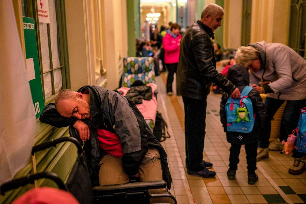 FILES: A Ukrainian evacuee sleeps in the hall of the main railway station in Przemysl, near the Polish-Ukrainian border, on March 20, 2022. AFPPIX