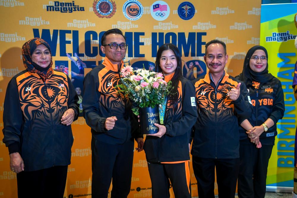 SEPANG, August 9 -- Gymnast Ng Joe Ee who won two gold medals at the Birmingham 2022 Commonwealth Games coach with a bouquet of flowers from the Secretary General of the Ministry of Youth and Sports Abdullah Hasan (second, left) arrived at the Kuala Lumpur International Airport (KLIA) with national sports team today. BERNAMAPIX