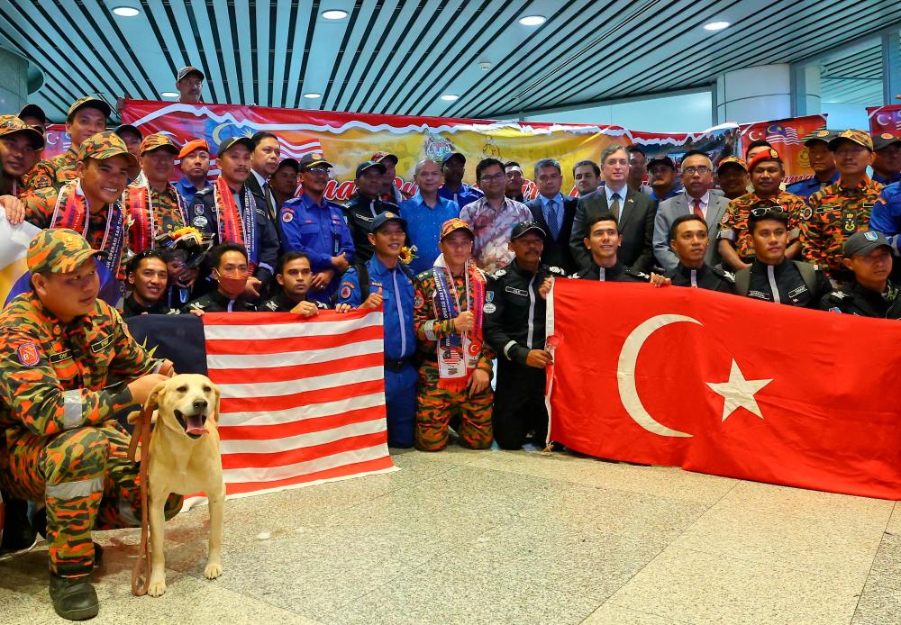 SEPANG, 23 Feb -- Minister in the Prime Minister’s Department (Sabah, Sarawak Affairs and Special Duties) Datuk Armizan Mohd Ali (centre) poses with members of the Second Group (MAS-10) of the Malaysian Search and Rescue Team (SAR) after welcoming their arrival at Kuala Lumpur International Airport (KLIA) today. BERNAMAPIX