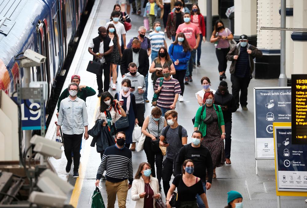 People, some wearing protective face masks, walk through Waterloo Station, amid the coronavirus disease (Covid-19) pandemic, in London, Britain. REUTERSPix