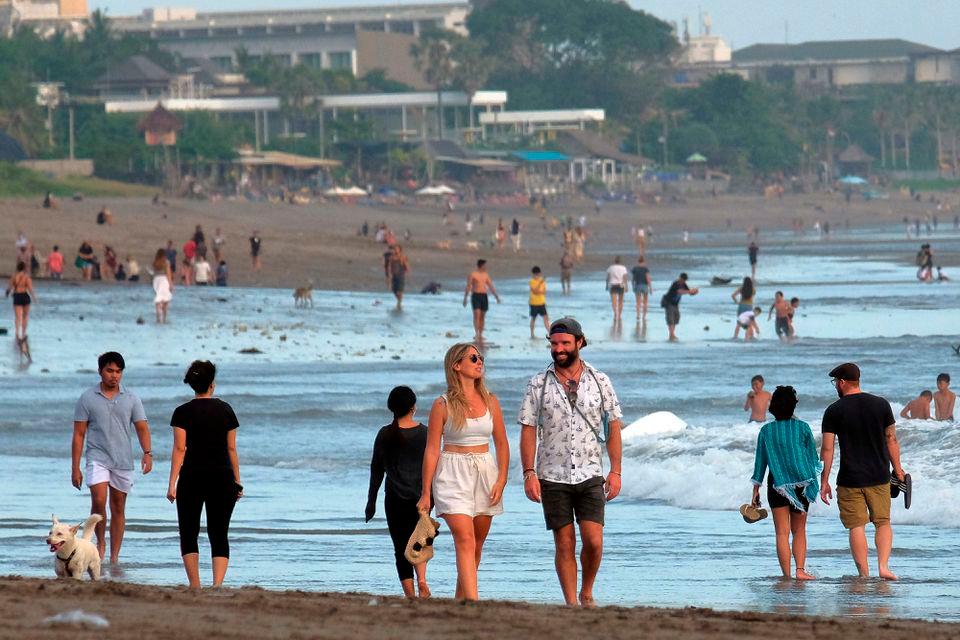 Tourists walk on a beach as the government extends restrictions to curb the spread of coronavirus disease (Covid-19) in Badung, Bali, Indonesia September 9, 2021. REUTERSPIX