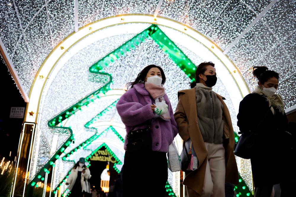 Women wearing masks to prevent contracting the coronavirus disease (Covid-19) walk under a Christmas illumination at a shopping district in central Seoul, South Korea, December 1, 2021. REUTERSpix
